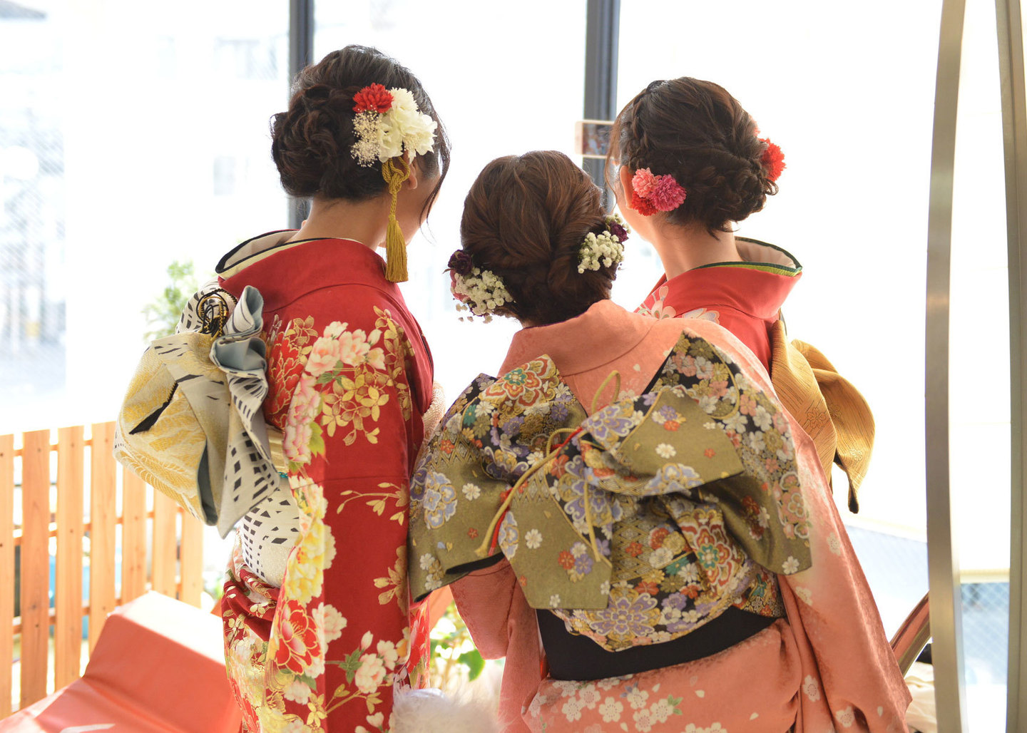 広島県三原市の成人式当日、冨士写真館で着付けを終えた新成人の皆様。華やかな振袖姿と、一人ひとりの個性に合わせた豪華な帯結び、繊細なヘアセットが並ぶ晴れやかな後ろ姿のスナップ。